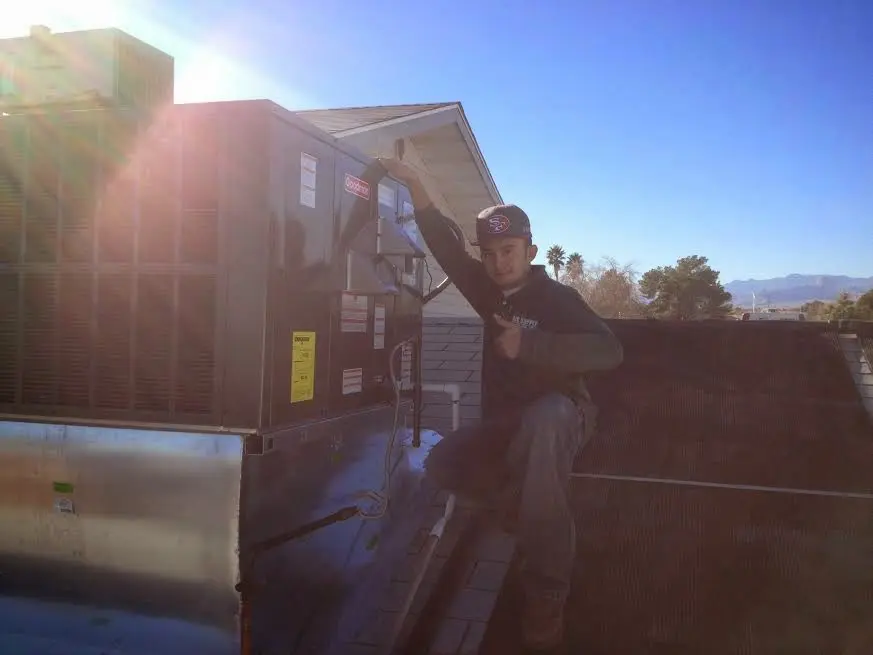 HVAC technician performing Boiler Repair on a rooftop unit in Carver